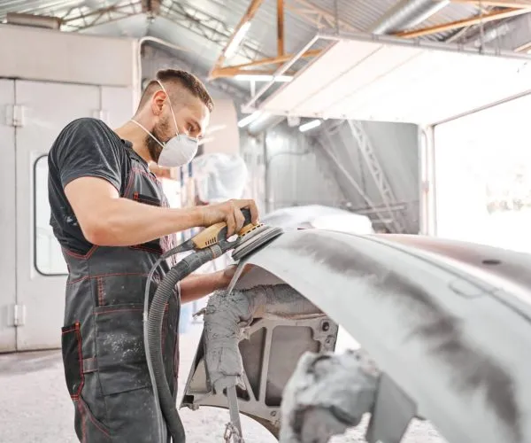 The,Mechanic,Works,With,A,Grinding,Tool.,Sanding,Of,Car The,Mechanic,Works,With,A,Grinding,Tool.,Sanding,Of,Car